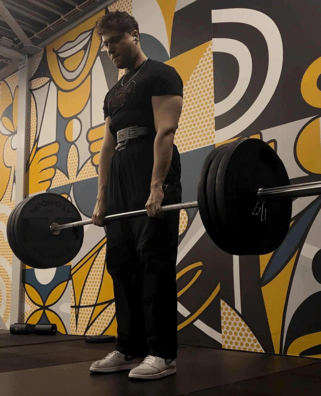 Jeffrey in 't Veld tijdens een deadlift, met een kunstwerk op de achtergrond