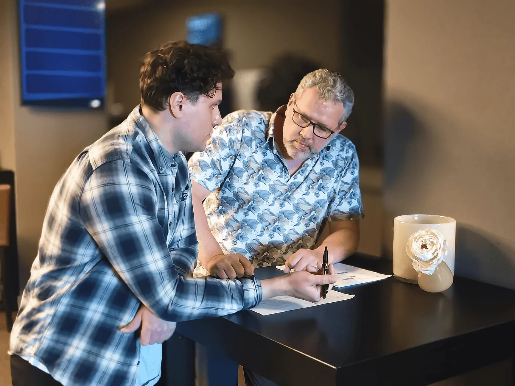 Twee mensen die samen aantekeningen bespreken aan een tafel
